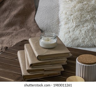 Interior items, an extinguished candle, on a stack of books