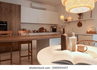 Interior of kitchen with dining table, counters and glowing lamps in evening