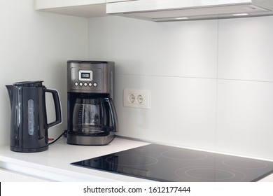 The Interior Of The Kitchen With Electric Appliances, Hood, Kettler, Coffee Maker And Stovetop 