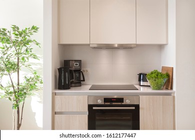 The Interior Of The Kitchen With Electric Appliances, Hood, Kettler, Coffee Maker, Stovetop And Oven