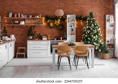 Interior of kitchen with glowing Christmas trees, dining table and counters - Powered by Shutterstock