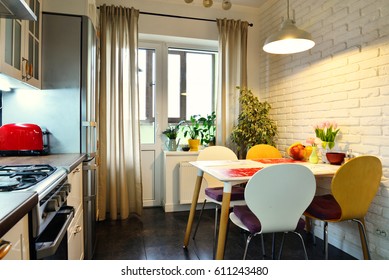 Interior of the kitchen in Scandinavian style with white furniture and a dining table