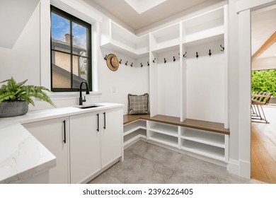Interior of large spacious laundry rooms featuring stainless and white appliances tiled flooring wooden cabinets clean and empty rooms for household duties and chores