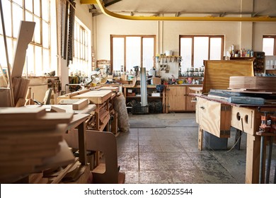 Interior of a large woodworking shop full of tools, machinery and an assortmant of wood planks and boards - Shutterstock ID 1620525544