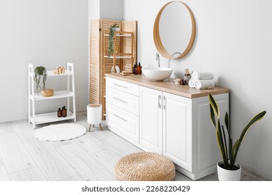 Interior of light bathroom with counters, sink and mirror - Shutterstock ID 2268220429