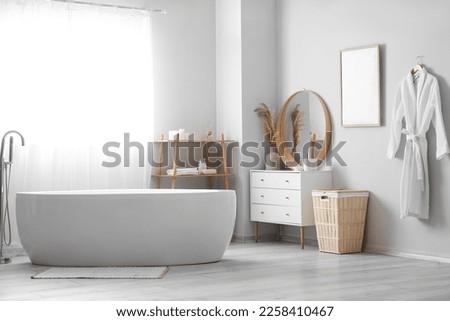 Interior of light bathroom with drawers, shelving unit and basket