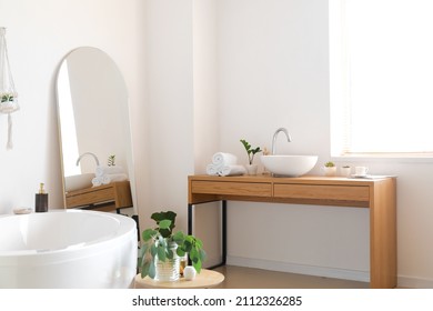 Interior of light bathroom with mirror and table - Shutterstock ID 2112326285