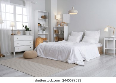 Interior of light bedroom with shelf units and glowing lamps