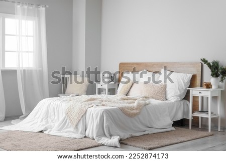 Interior of light bedroom with white tables and chair