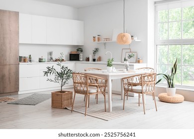 Interior of light dining room with table and wicker chairs