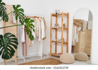 Interior Of Light Dressing Room With Stylish Clothes, Shoes And Mirror