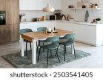 Interior of light kitchen with dining table and white counters