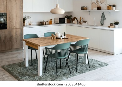 Interior of light kitchen with dining table and white counters