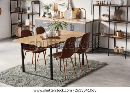 Interior of light kitchen with dining table and plants