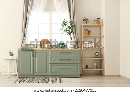 Interior of light kitchen with green counters, window, sink and shelving unit