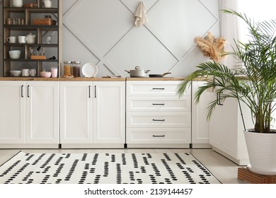 Interior of light kitchen with white counters, shelving unit and food