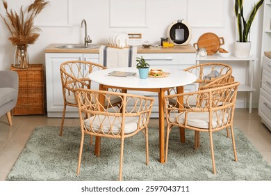 Interior of light kitchen with white counters and dining table