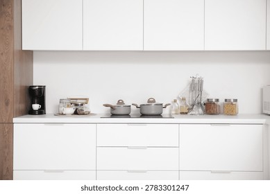 Interior of light kitchen with white counters and utensils
