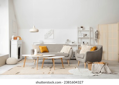 Interior of light living room with electric fireplace, armchair and sofa - Shutterstock ID 2381604327