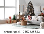 Interior of light living room with grey sofa, Christmas tree and festive decorations