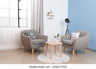 Interior Of Light Living Room With Grey Armchairs And Curtains