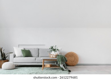 Interior de la sala de estar ligera con sofá gris, banco suave y pufs