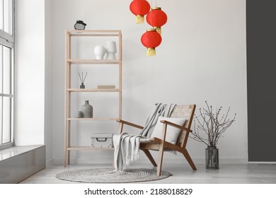 Interior of light living room with shelving unit, armchair and Chinese lanterns - Shutterstock ID 2188018829
