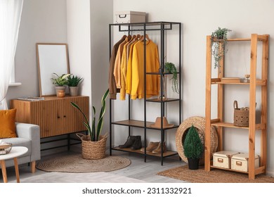 Interior of light living room with shelving unit and clothes - Shutterstock ID 2311332921
