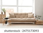 Interior of light living room with sofa and glucophone on table