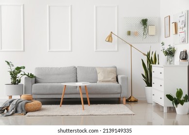 Interior of light living room with sofa and hanging peg boards - Shutterstock ID 2139149335