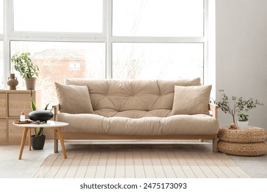 Interior of light living room with sofa and glucophone on table