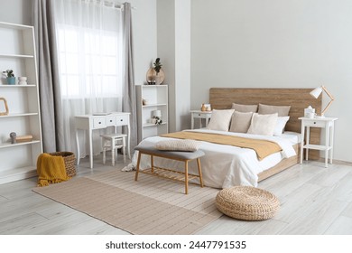 Interior of light modern bedroom with big bed, shelving units and bedside table