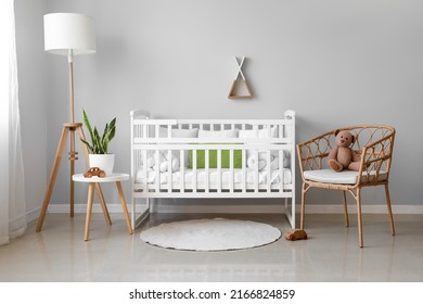 Interior Of Light Nursery With Baby Crib, Lamp, Table And Armchair