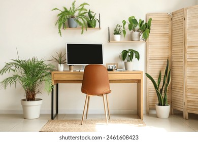 Interior of light office with workplace, shelves and green houseplants - Powered by Shutterstock