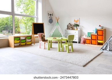 Interior of light playroom with toys, teepee and chalkboard in kindergarten - Powered by Shutterstock