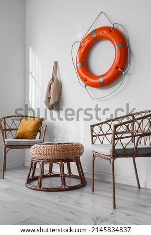 Interior of light room with ring buoy and armchairs
