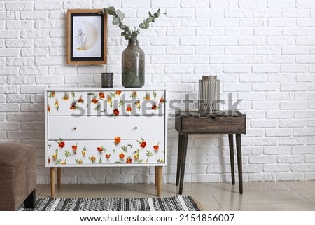 Interior of light room with stylish chest of drawers
