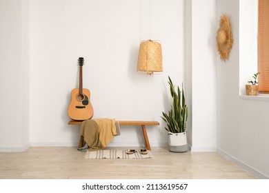 Interior Of Light Room With Wooden Bench, Guitar And Houseplant