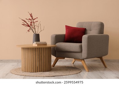 Interior de la sala de estar con sillón, cojín y mesa de centro con decoración cerca de la pared beige