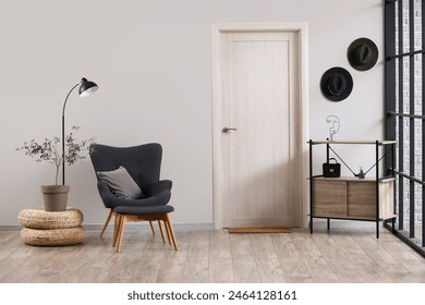 Interior of living room with black armchair, door and shelf unit