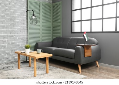 Interior Of Living Room With Black Sofa, Table And UAE Flag