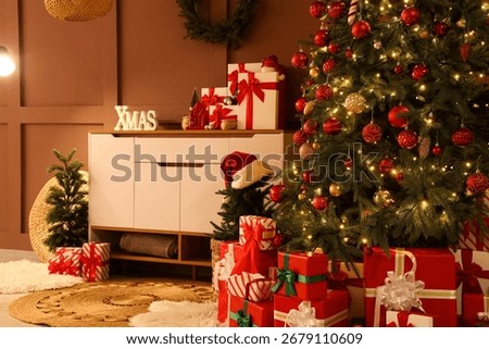 Interior of living room with commode, Christmas trees and presents