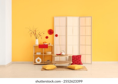 Interior of living room decorated for Chinese New Year with table, shelf unit and folding screen