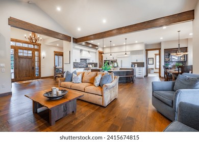 Interior living room with fireplace stone and wood mantle staircase wooden flooring decorated and staged large bright windows classic and modern decor - Powered by Shutterstock