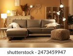 Interior of living room with glowing lamp, comfortable sofa and shelving unit at evening