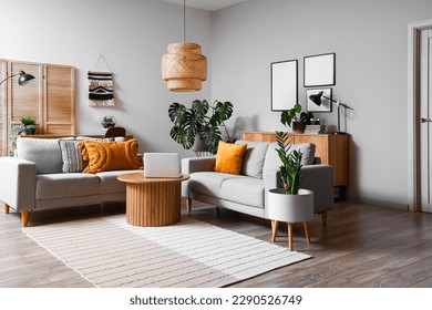 Interior of living room with green houseplants and sofas - Powered by Shutterstock