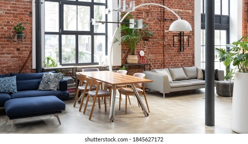 Interior Of Living Room In Industrial Style In Loft Apartment. Brick Wall, Big Wall, Wooden Table And Navy Sofa In Stylish Room At Home. Banner.