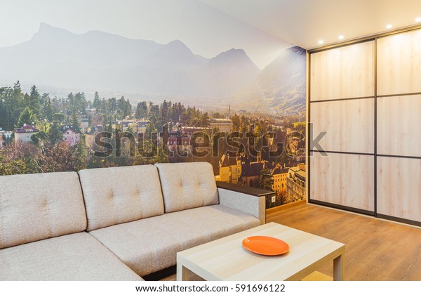 The interior of the living room in orange tones with sofa. Removable wall mural. 