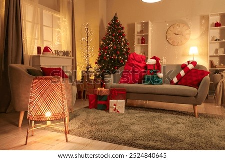 Interior of living room with Santa bag and Christmas presents on sofa at night