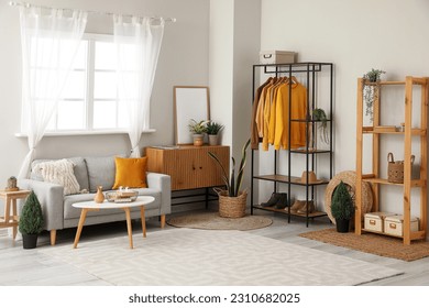 Interior of living room with shelving unit, clothes and sofa - Shutterstock ID 2310682025